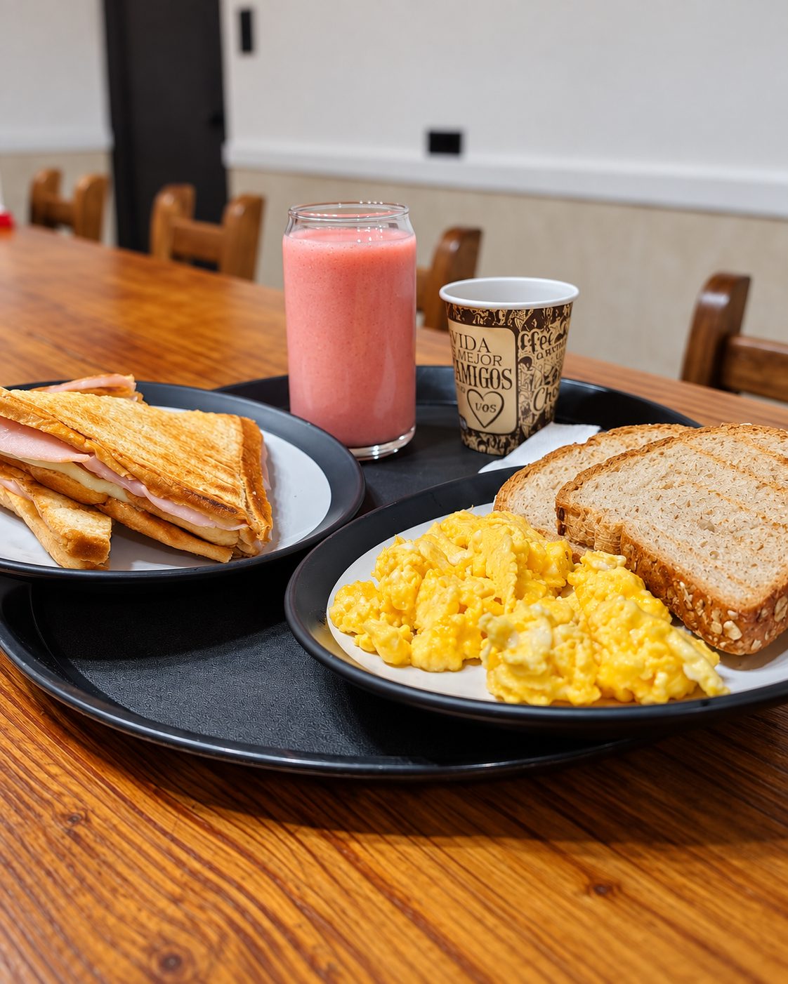 Desayuno de Dulce Vida con sándwich tostado, huevos revueltos, pan integral y jugo